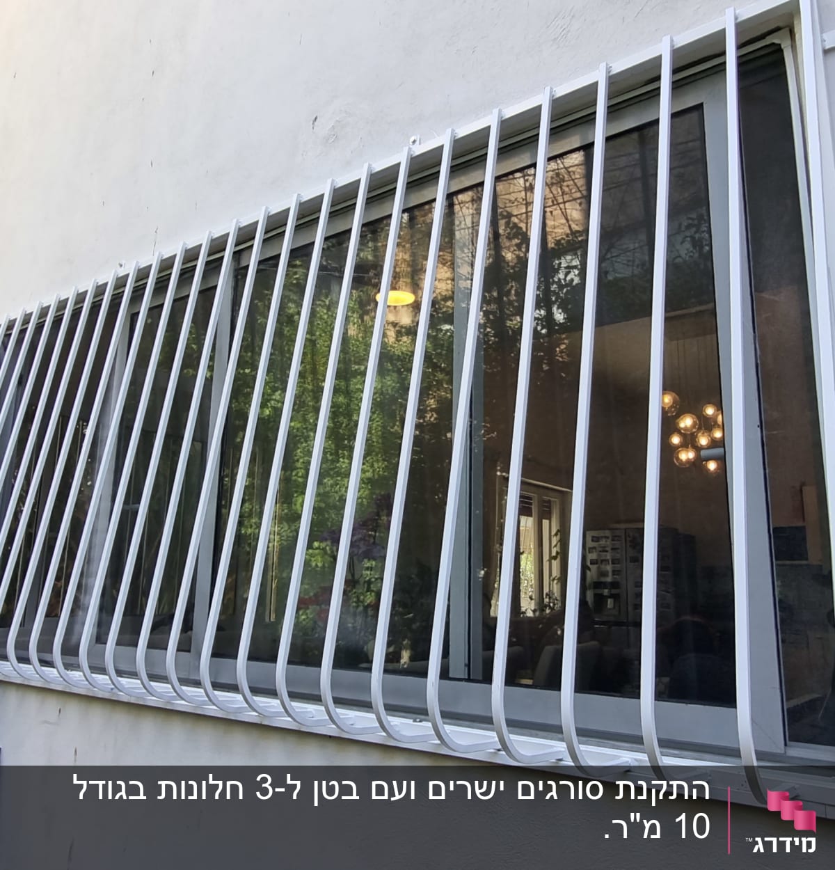 סורגי מתכת לבנים על חלון זכוכית גדול